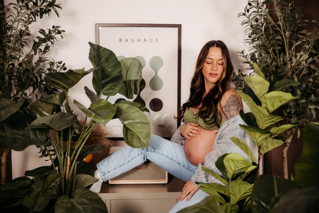 Babybauchshooting wie im Dschungel. Zwischen vielen Zimmerpflanzen und passendem Outfit haben wir den Babybauch in Bildern festgehalten. Familienfotografie mal anders