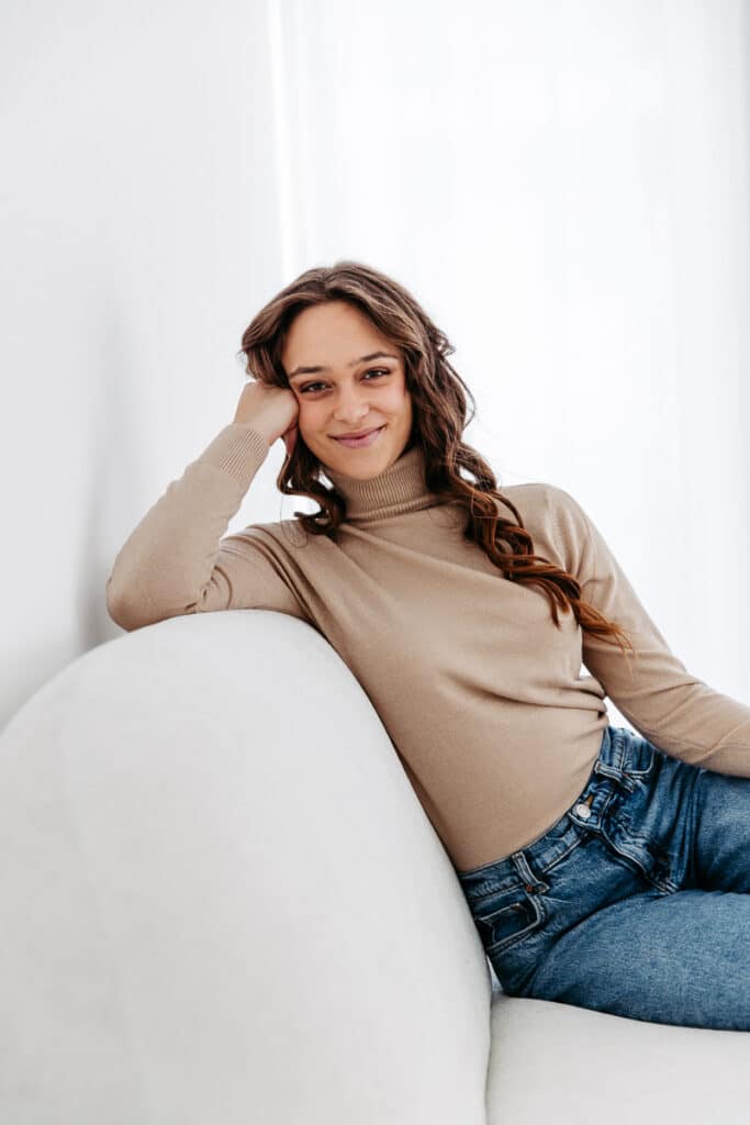 moderne Bewerbungsbilder. Sitzend in die Kamera lachen. Sehr schlichtes Set, viel weiß und hell. Wirkt offen und freundlich