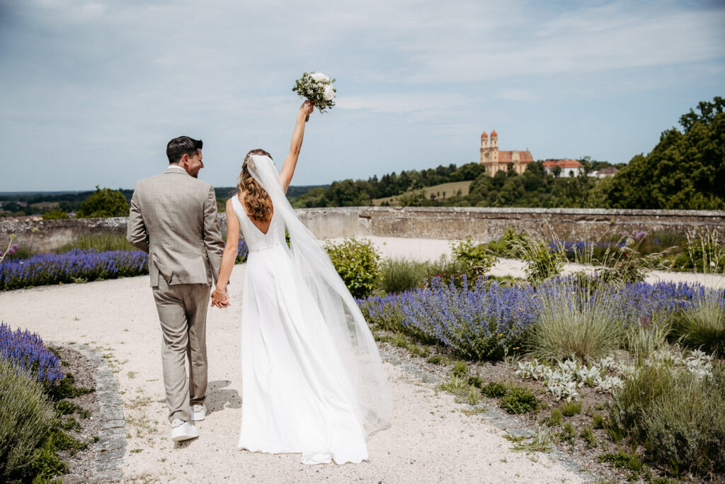 Hochzeitspaar im Schloss Ellwangen, Outdoorshooting, Paarshooting im Schlossgarten, Im Hintergrund Kirche Ellwangen, Vorfreude, Braut